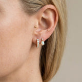Lumi Opal Hoops in yellow gold, worn on a model