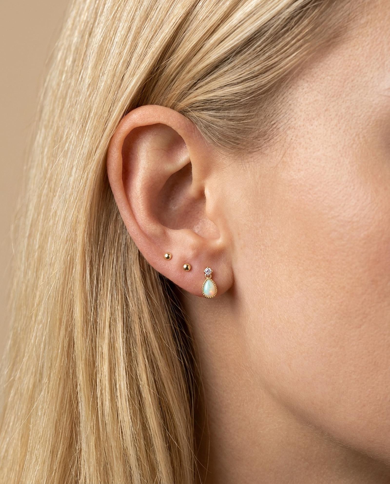 Suri Opal Teardrop Studs in yellow gold, worn on a model