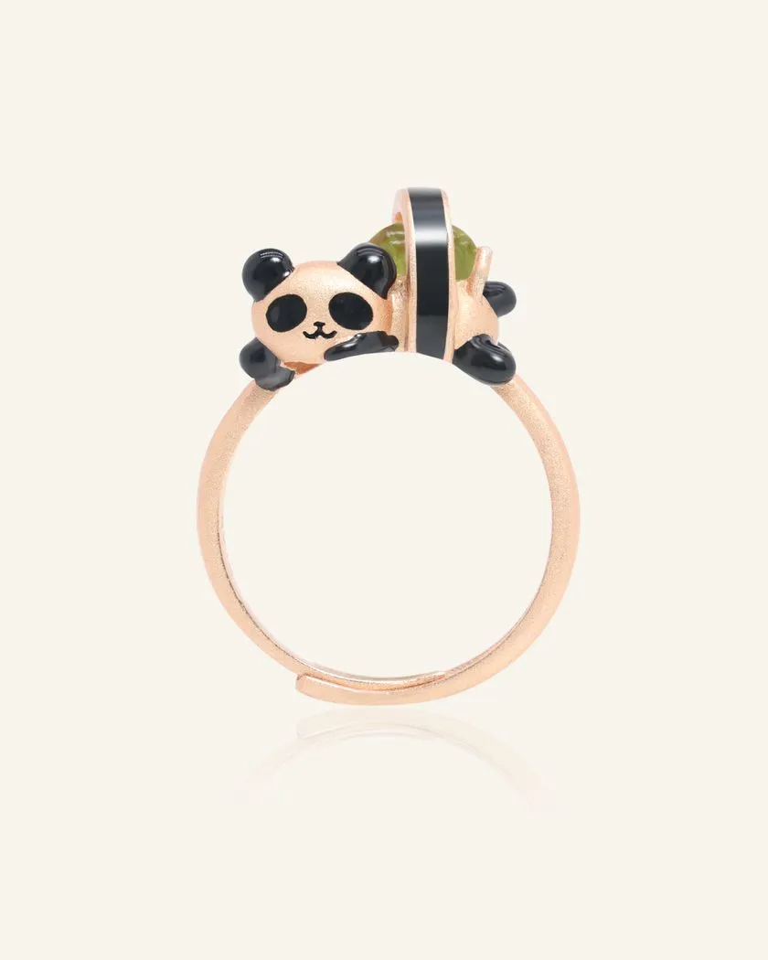 A whimsical panda sushi roll ring crafted in rose gold, featuring an adorable panda as a sushi roll. The sushi roll is set with a vibrant peridot gemstone, adding a playful and elegant touch.
