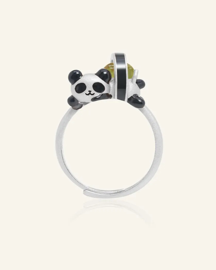 A whimsical panda sushi roll ring crafted in silver, featuring an adorable panda as a sushi roll. The sushi roll is set with a vibrant peridot gemstone, adding a playful and elegant touch.