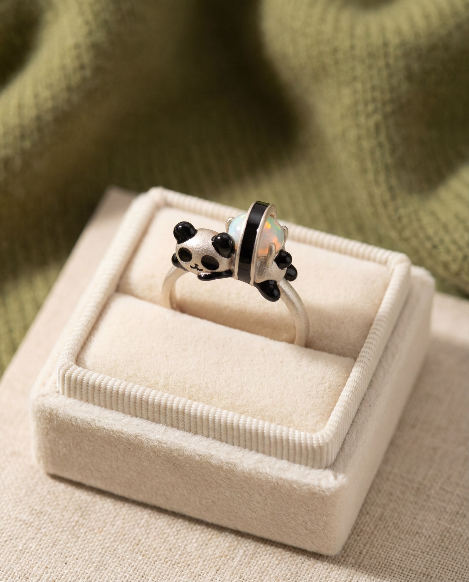Panda Sushi Roll Ring (Opal) in silver, laid flat on a tabletop