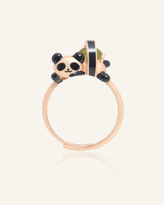 Panda Sushi Roll Ring (Peridot) in rose gold, resting on a warm linen background