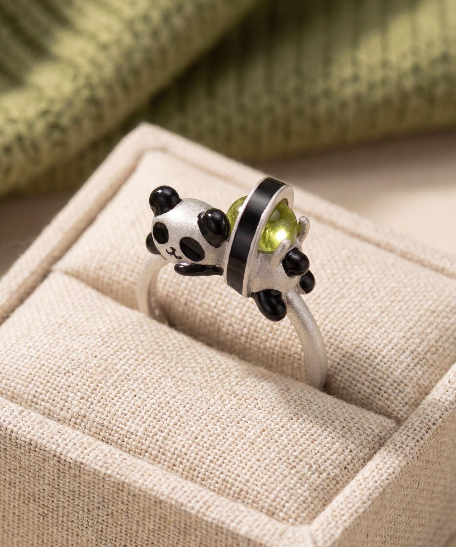 Panda Sushi Roll Ring (Peridot) in silver, laid flat on a tabletop