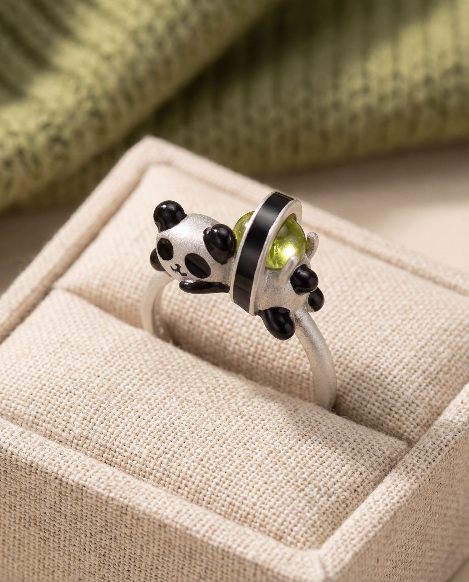 Panda Sushi Roll Ring (Peridot) in silver, laid flat on a tabletop