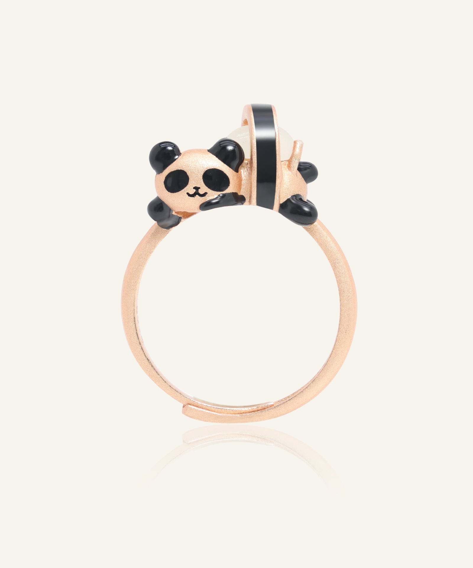 Close-up of the Panda Sushi Roll Ring (White Jade) in rose gold, resting on a warm linen background