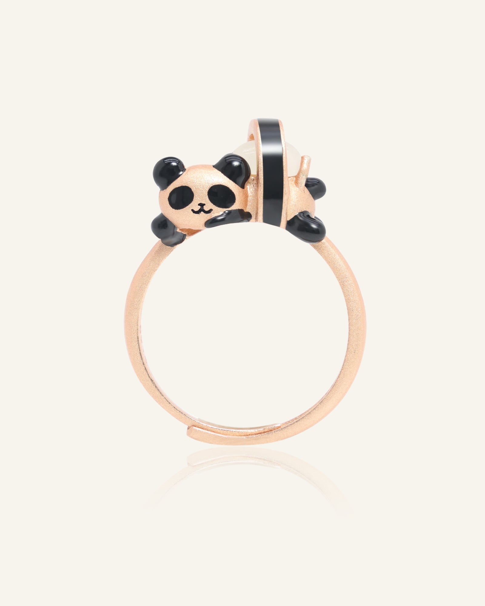 Close-up of the Panda Sushi Roll Ring (White Jade) in rose gold, resting on a warm linen background
