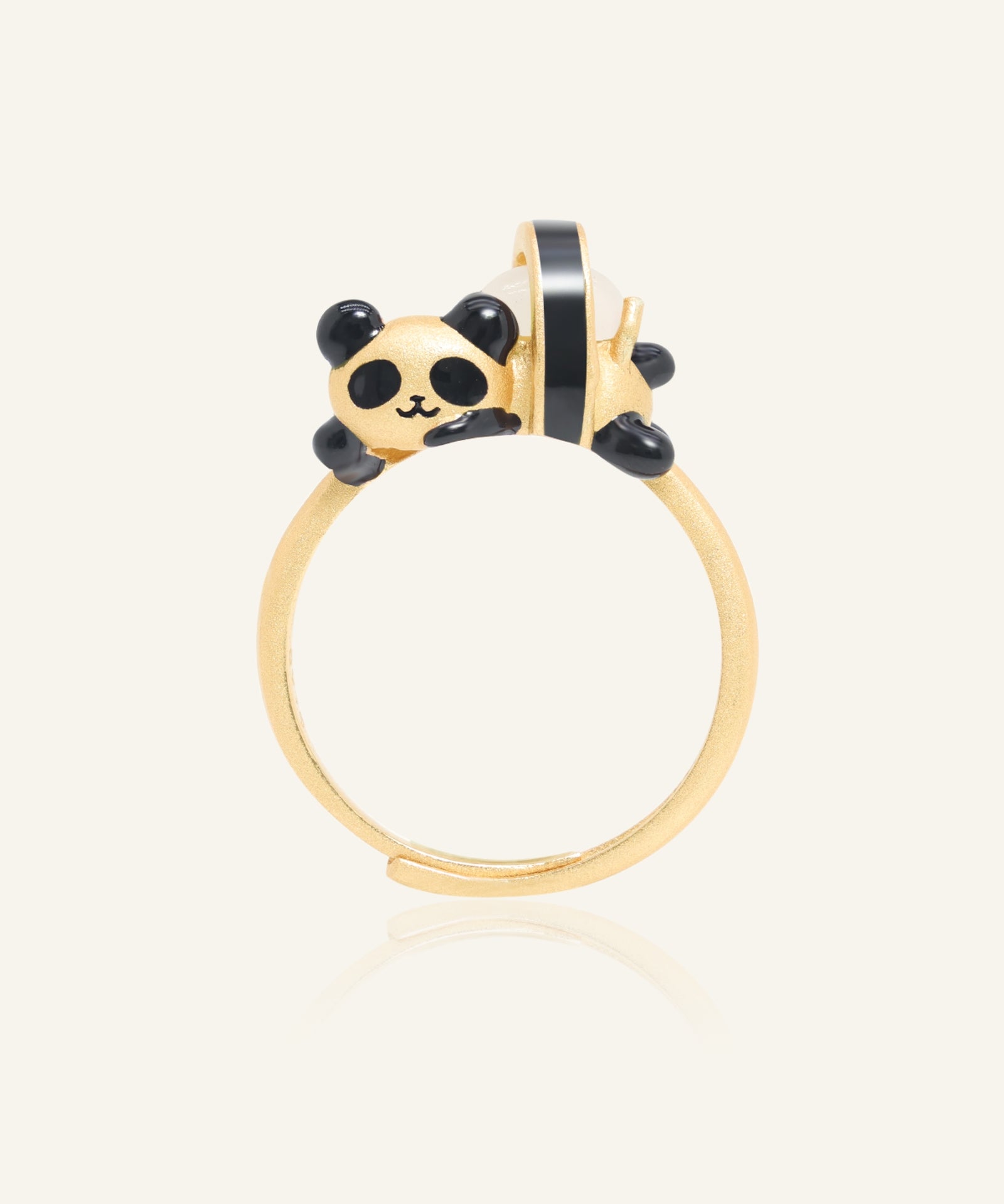 Panda Sushi Roll Ring (White Jade) in yellow gold, resting on a warm linen background