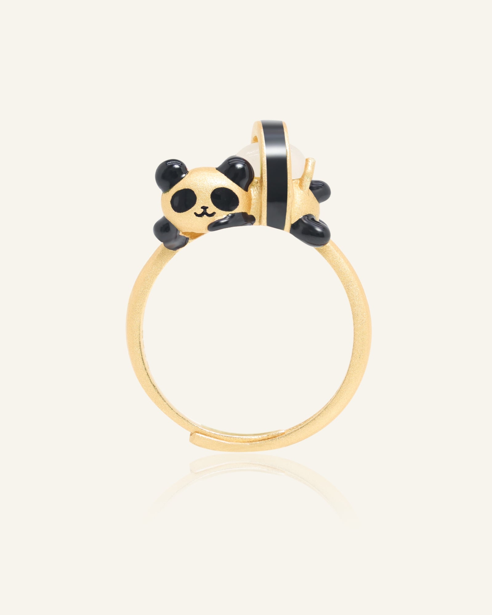 Panda Sushi Roll Ring (White Jade) in yellow gold, resting on a warm linen background