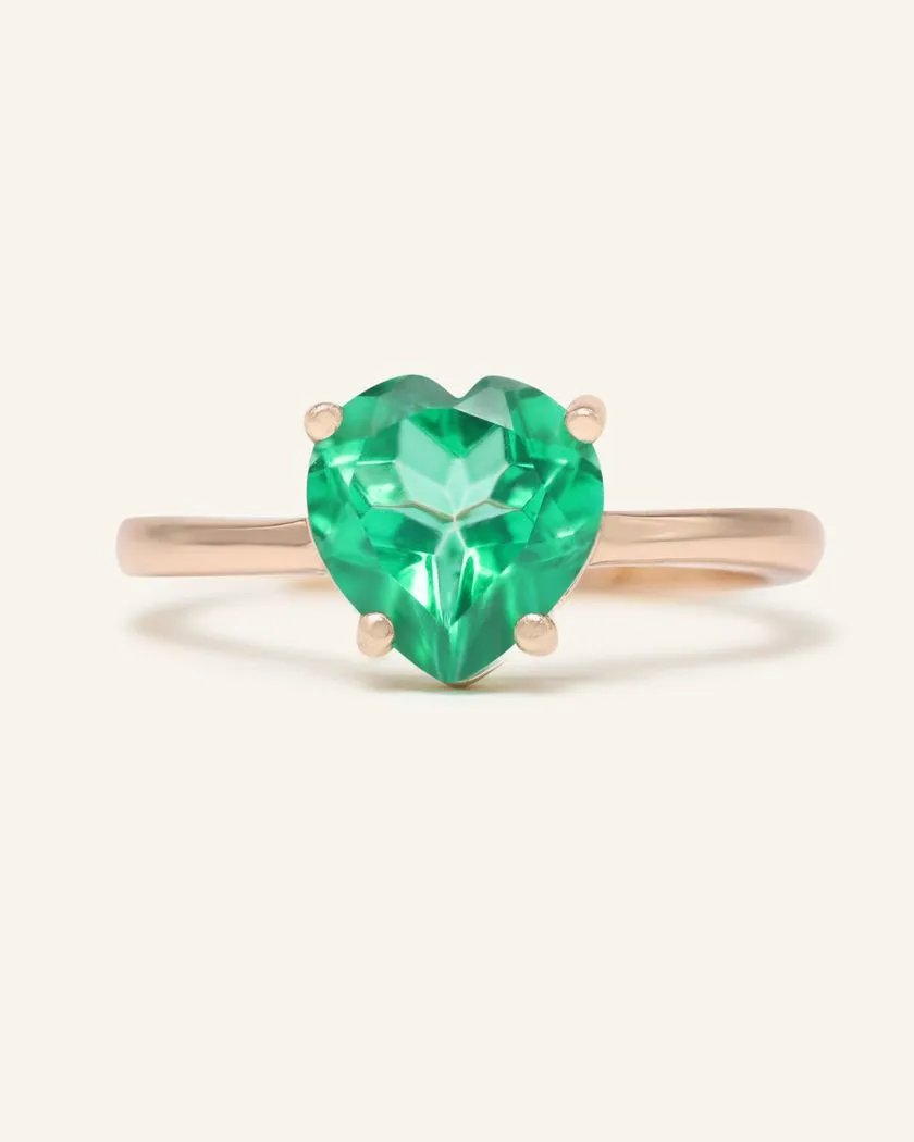 Paraiba topaz heart ring set in rose gold, featuring a vibrant green heart-shaped gemstone with a polished band.