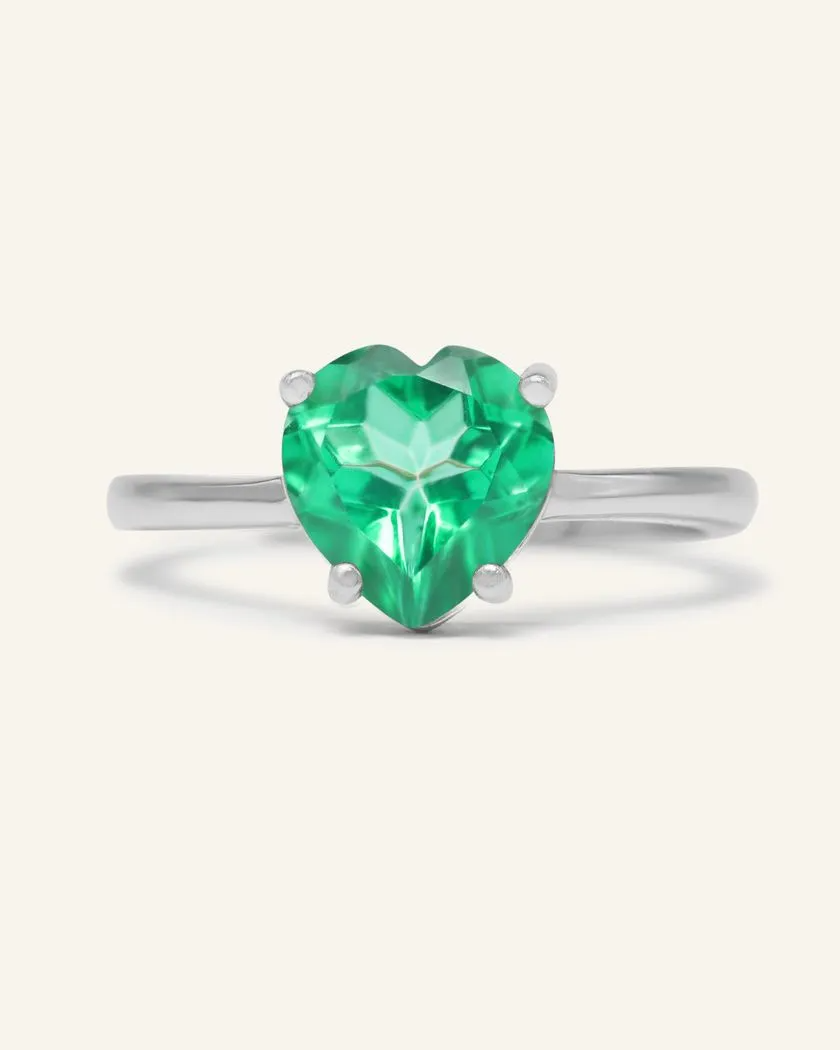 Paraiba topaz heart ring set in silver, featuring a vibrant green heart-shaped gemstone with a polished band.	