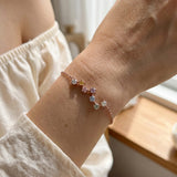 A lifestyle photograph of the rose gold Pastel Constellation Moissanite Bracelet worn elegantly on a model's wrist, highlighting how the delicate star-cluster layout sits beautifully as a standalone piece.