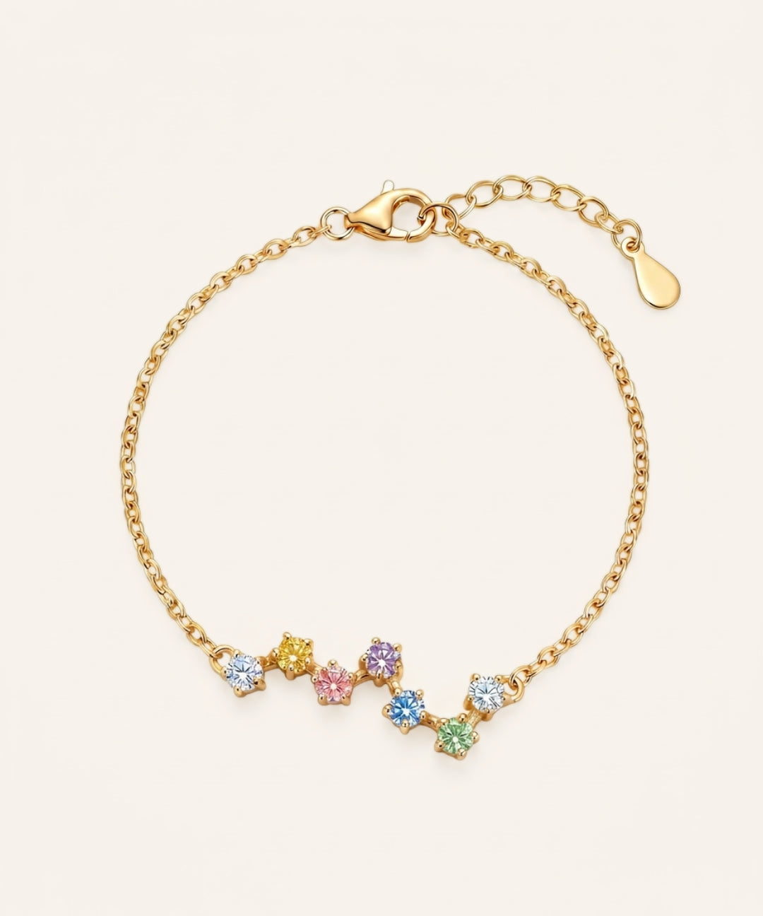 A top-down studio product photograph of the Pastel Constellation Moissanite Bracelet in yellow gold, highlighting the vibrant yellow metal paired with the soft, rainbow-inspired gradient of clear, yellow, pink, purple, blue, and green stones.
