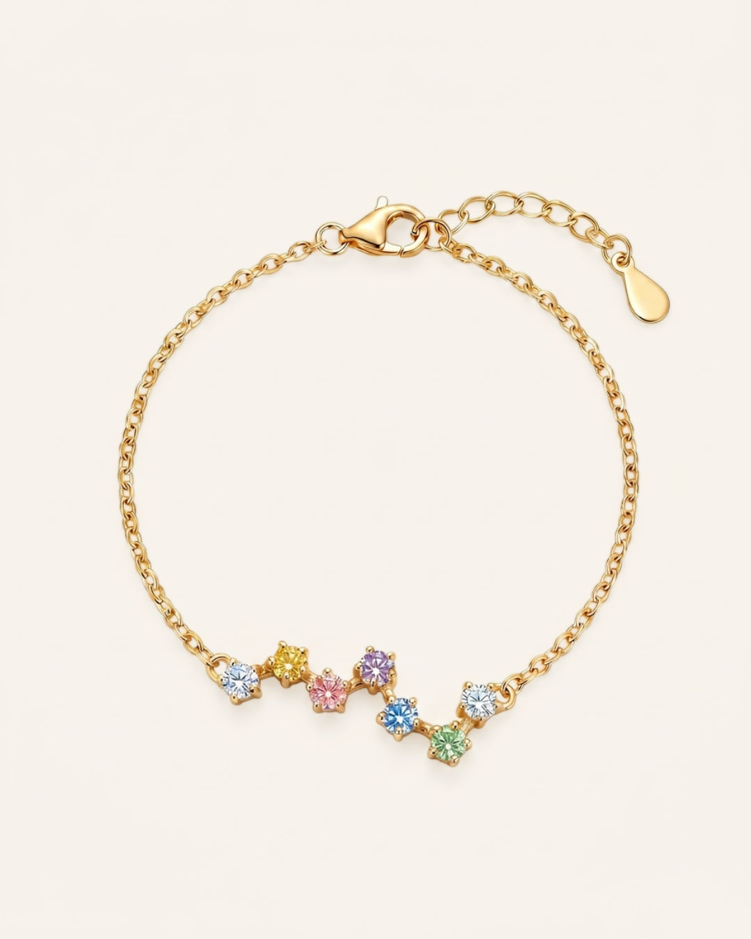 A top-down studio product photograph of the Pastel Constellation Moissanite Bracelet in yellow gold, highlighting the vibrant yellow metal paired with the soft, rainbow-inspired gradient of clear, yellow, pink, purple, blue, and green stones.