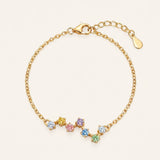 A top-down studio product photograph of the Pastel Constellation Moissanite Bracelet in yellow gold, highlighting the vibrant yellow metal paired with the soft, rainbow-inspired gradient of clear, yellow, pink, purple, blue, and green stones.