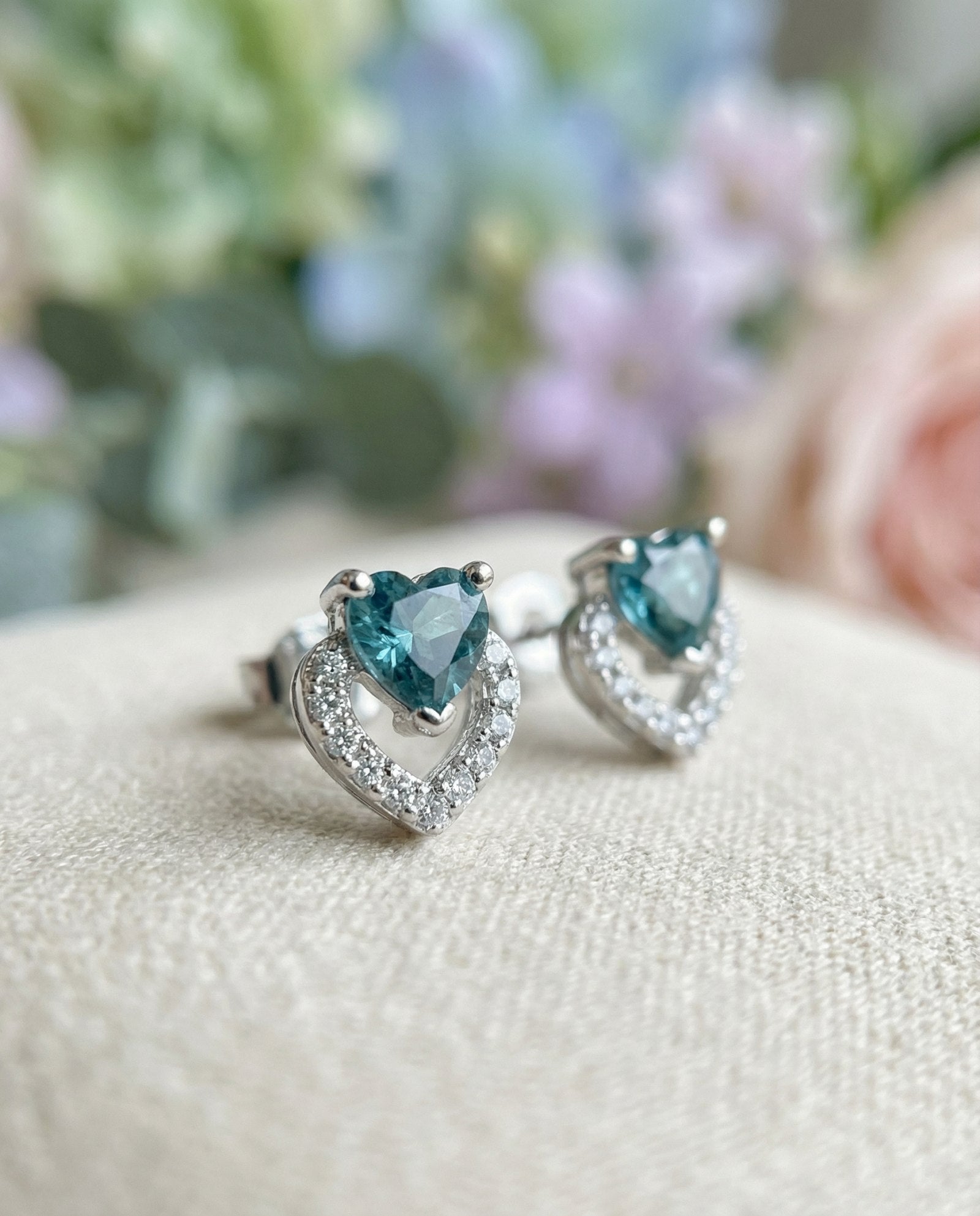 Macro photograph of Petite Blue Tourmaline Heart Studs showing the intricate pavé setting and heart-cut gemstone detail.