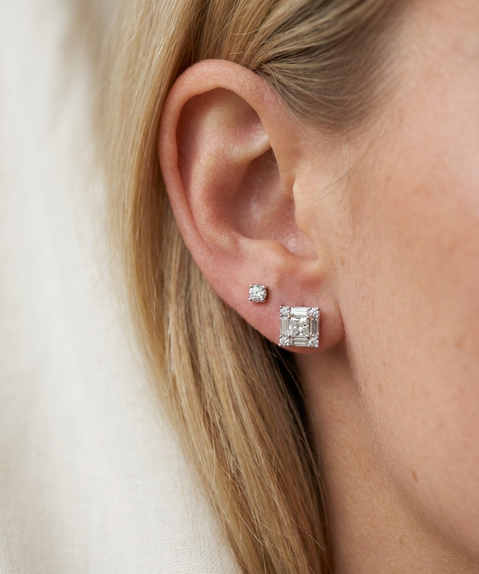 Model wearing sterling silver Petite Princess Mosaic Moissanite Stud in first lobe piercing alongside a small accent stud.