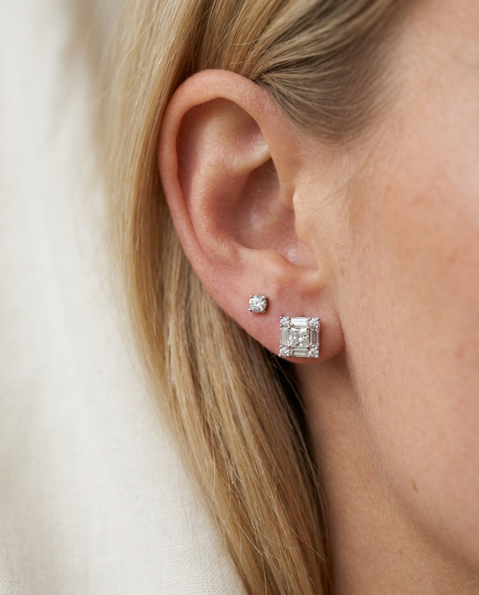 Model wearing sterling silver Petite Princess Mosaic Moissanite Stud in first lobe piercing alongside a small accent stud.
