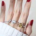 A model wearing a silver ring featuring a mother of pearl centerpiece shaped like a pig's head.