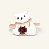 Close-up of the Polar Bear Garnet Ring in rose gold, resting on a warm linen background