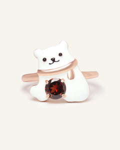 Close-up of the Polar Bear Garnet Ring in rose gold, resting on a warm linen background
