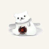 Polar Bear Garnet Ring in silver, resting on a warm linen background