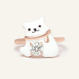 Close-up of the Polar Bear Moissanite Ring in rose gold, resting on a warm linen background