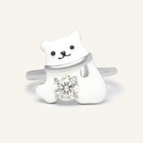 Polar Bear Moissanite Ring in silver, resting on a warm linen background