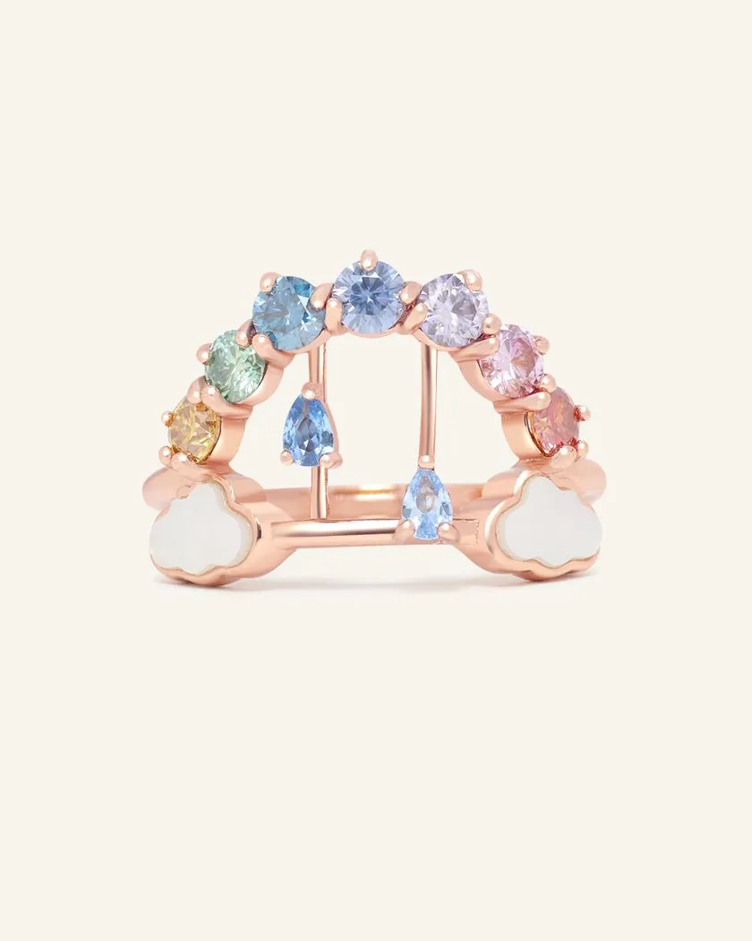 Rose gold Rainbow's Promise ring showcasing a vibrant gradient of moissanites in rainbow hues, accented with delicate cloud motifs and pear-cut blue cubic zirconias raindrops for a whimsical and elegant design.