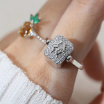 A model wearing a silver ring featuring a reversible rectangular citrine gemstone adorned with intricate carvings and surrounded by cubic zirconias.