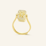 A yellow gold ring featuring a reversible rectangular citrine gemstone adorned with intricate carvings and surrounded by cubic zirconias.