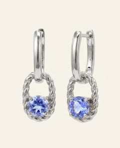 Close-up of the Rope Huggies | Tanzanite, Elate in silver, resting on a warm linen background