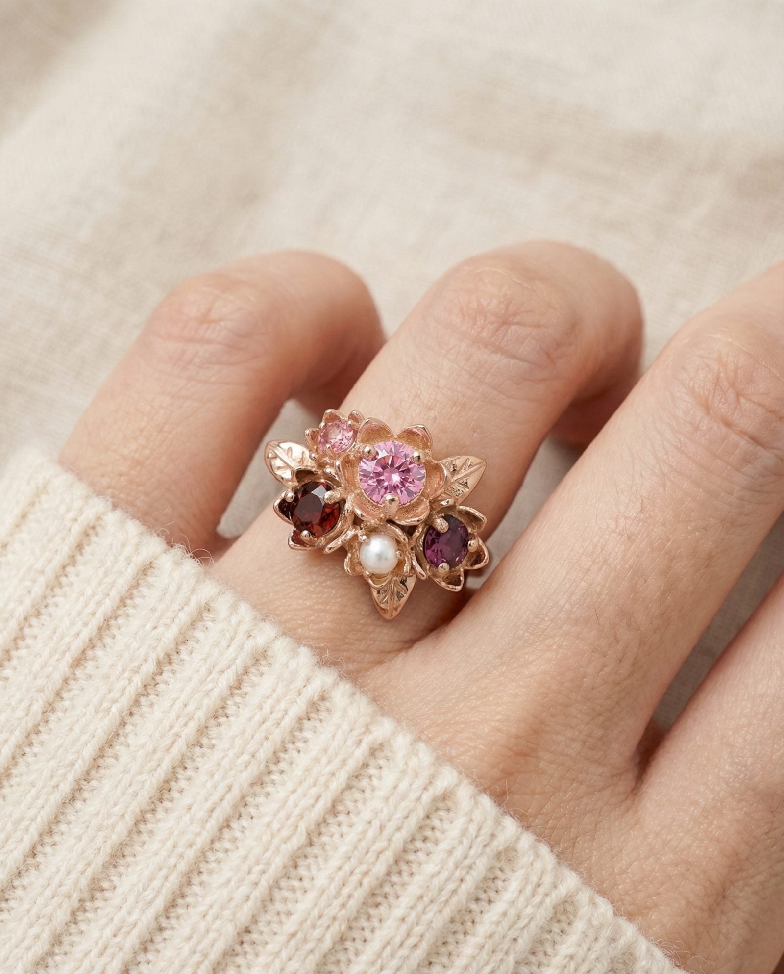Model wearing the Rosette Floral Cluster Ring styled with a cozy cream sweater to show everyday elegance.