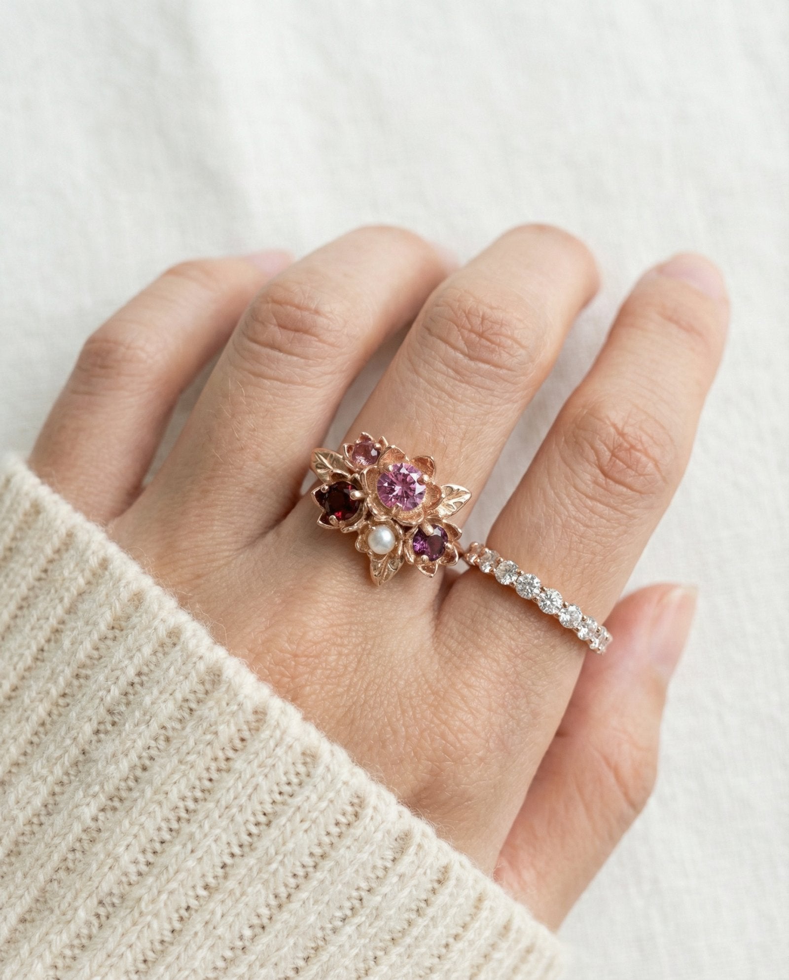 Model wearing the Rosette Floral Cluster Ring styled with a cozy cream sweater to show everyday elegance.