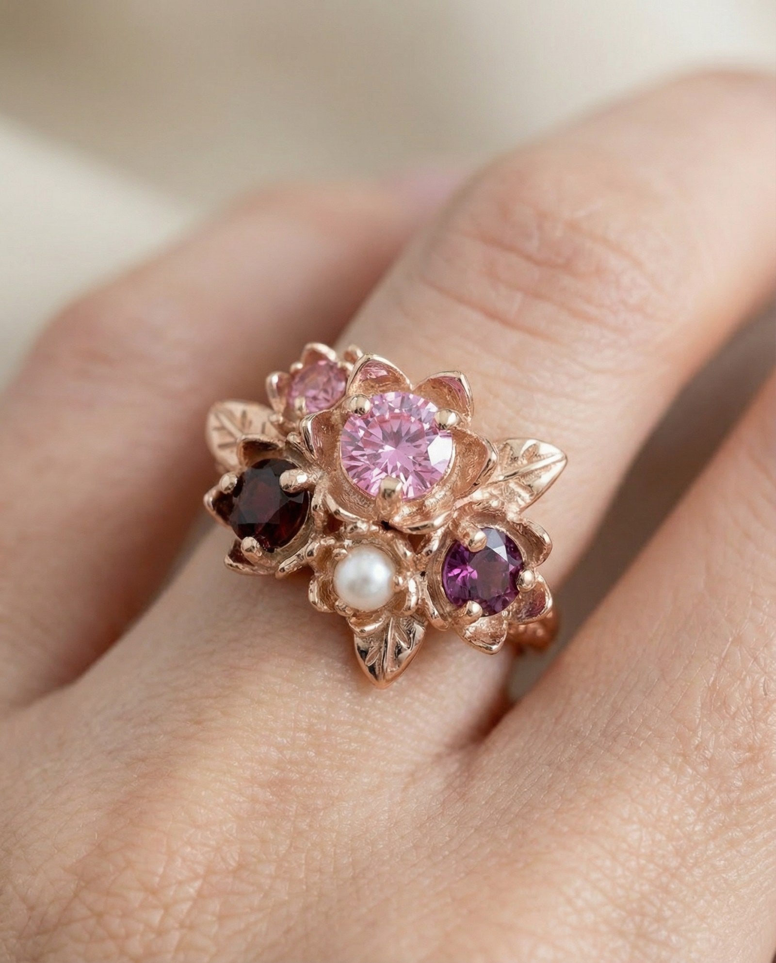 Macro photograph of the Rosette ring on a hand, highlighting the leaf details and pearl accent.