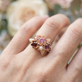 Close-up side view of the Rosette ring showing the 18k rose gold plating and gemstone settings.