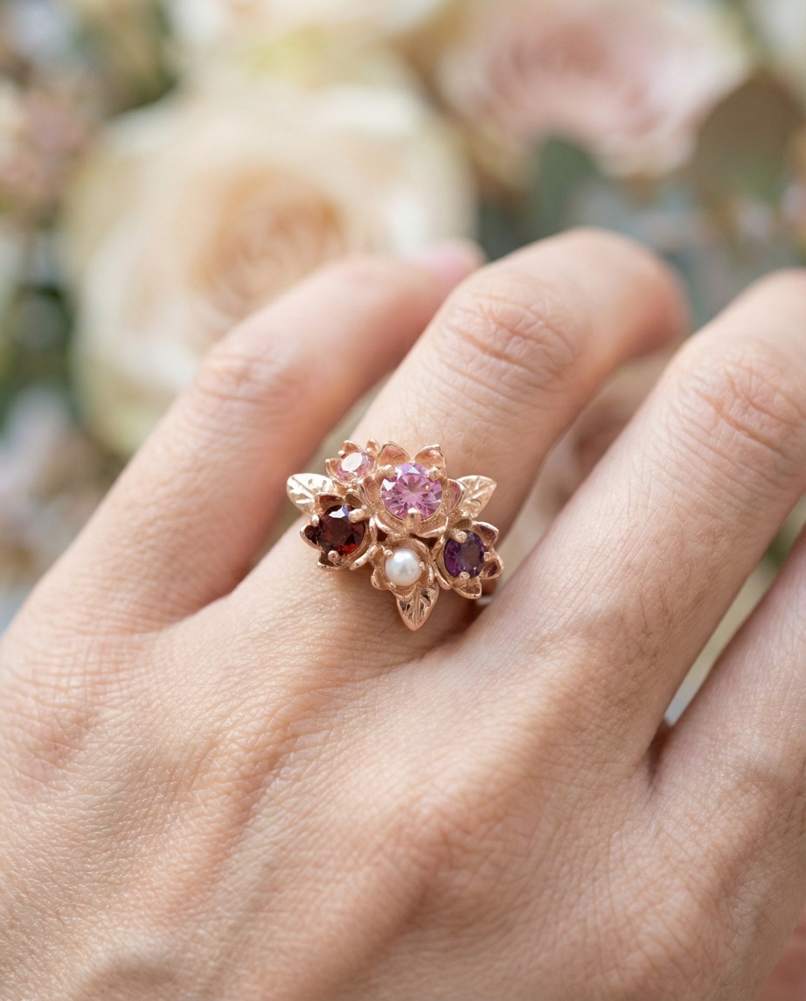 Close-up side view of the Rosette ring showing the 18k rose gold plating and gemstone settings.