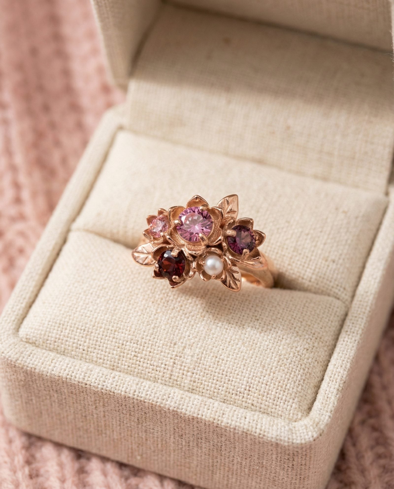 Rosette Floral Cluster Ring displayed in a luxury cream jewelry box with a soft pink knit background.