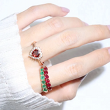 A model wearing the ruby half eternity band. The ring features a series of vibrant, deep red round-cut rubies set in a rose gold band, arranged in a continuous line around half of the band, showcasing a timeless and elegant design.