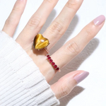 A model wearing the ruby half eternity band. The ring features a series of vibrant, deep red round-cut rubies set in a rose gold band, arranged in a continuous line around half of the band, showcasing a timeless and elegant design.