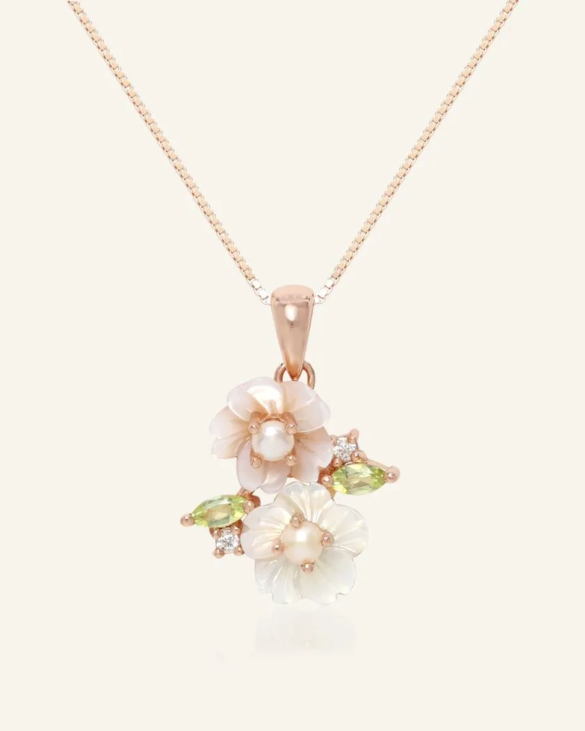 Sakura Blossom Necklace in rose gold, featuring hand-carved mother-of-pearl flowers, adorned with freshwater pearls and vibrant peridot accents, set in a delicate design.