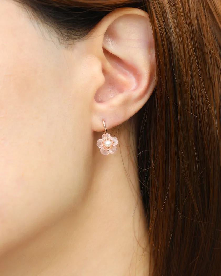 A model wearing the rose gold sakura hook earrings featuring hand-carved rose quartz petals and a luminous freshwater pearl centerpiece.	