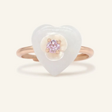 A delicate Sakura Jadeite Heart Ring in rose gold, featuring a jadeite heart centerpiece, a sparkling pink moissanite as the focal stone, and intricately carved mother-of-pearl flower petals for a touch of elegance.