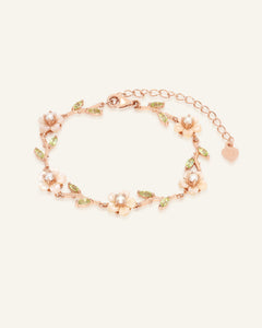 Sakura Twig Bracelet in rose gold, resting on a warm linen background