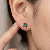 Model wearing Sculpted Heart Nest Moissanite Stud Earring in 18k rose gold vermeil with Celestial Teal center stone.