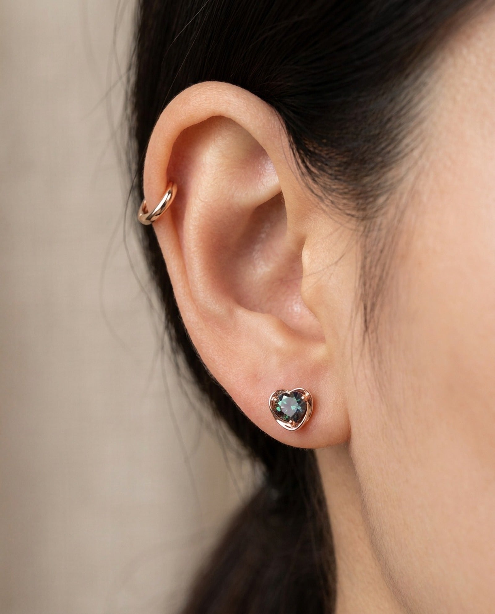 Side view of model wearing 18k rose gold Sculpted Heart Nest Moissanite Stud paired with a plain cartilage cuff.