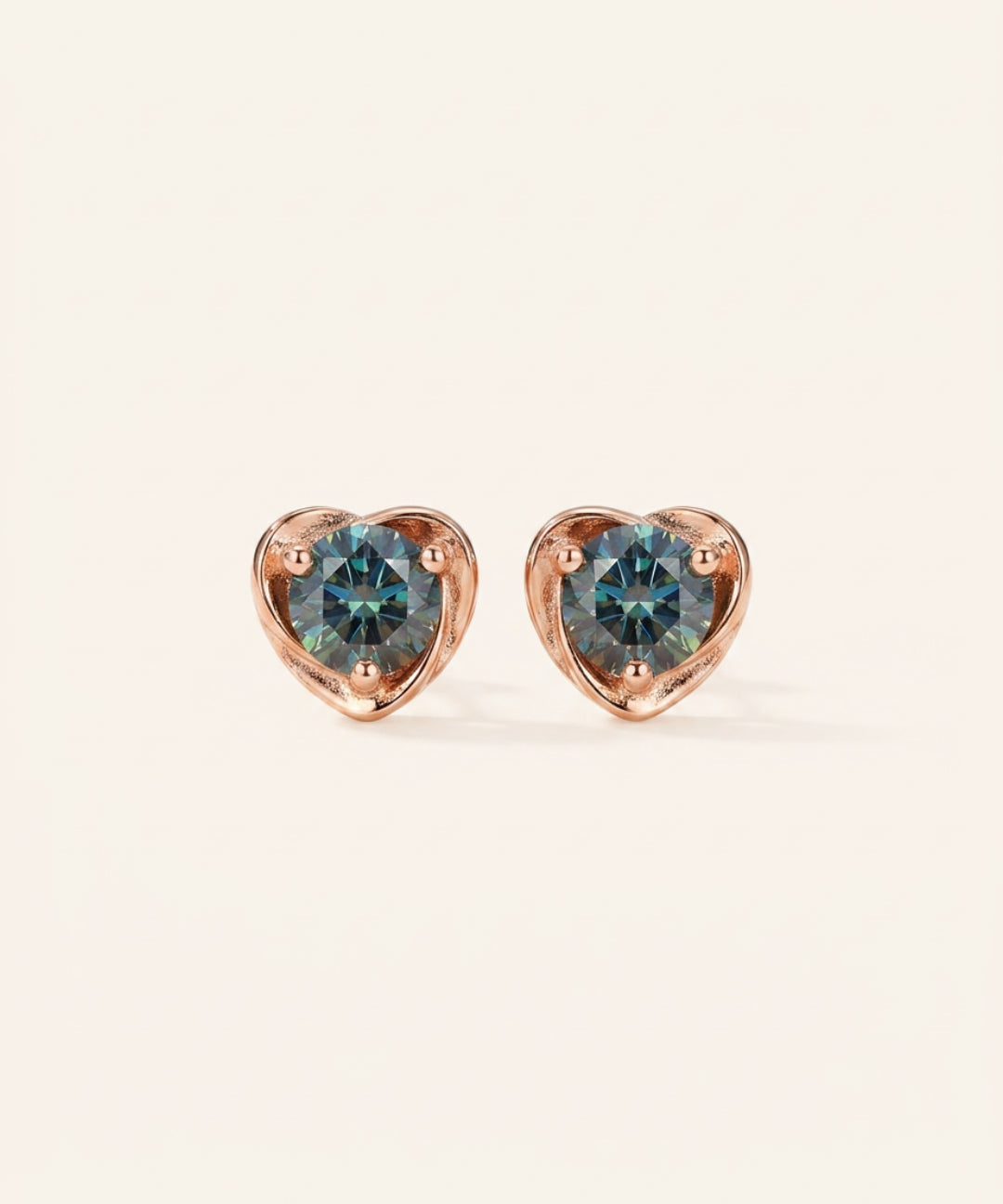 Pair of Sculpted Heart Nest Moissanite Stud Earrings in 18k rose gold vermeil with 5mm Celestial Teal stones.
