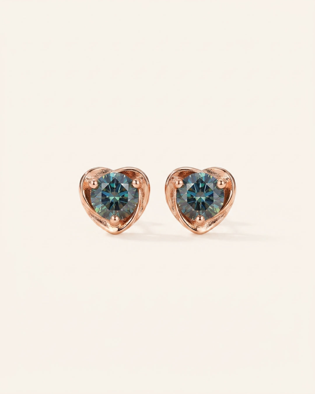 Pair of Sculpted Heart Nest Moissanite Stud Earrings in 18k rose gold vermeil with 5mm Celestial Teal stones.