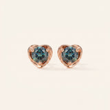Pair of Sculpted Heart Nest Moissanite Stud Earrings in 18k rose gold vermeil with 5mm Celestial Teal stones.