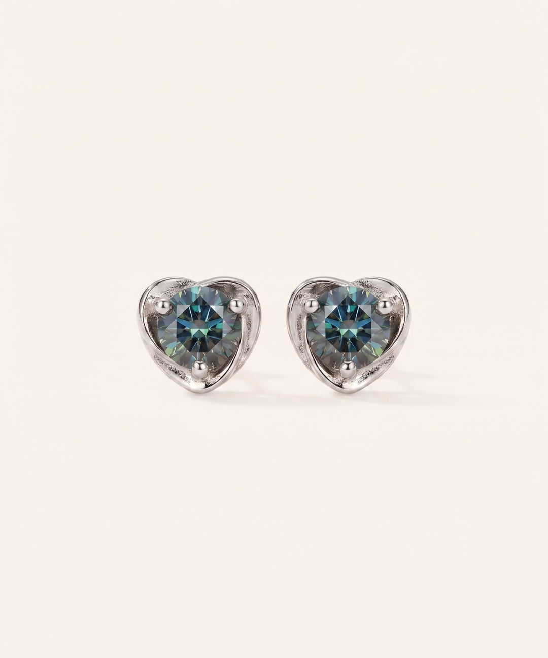 Pair of Sculpted Heart Nest Moissanite Stud Earrings in sterling silver featuring round Celestial Teal moissanite center stones.