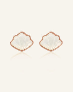 Seashell Mother of Pearl Studs in rose gold, resting on a warm linen background